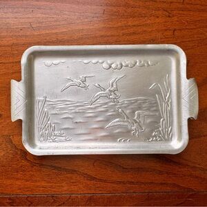 Vintage hammered aluminum trinket trays with water scene.